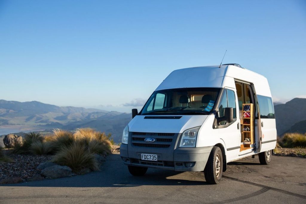 quirky camper parked up in new zealand with mountain background