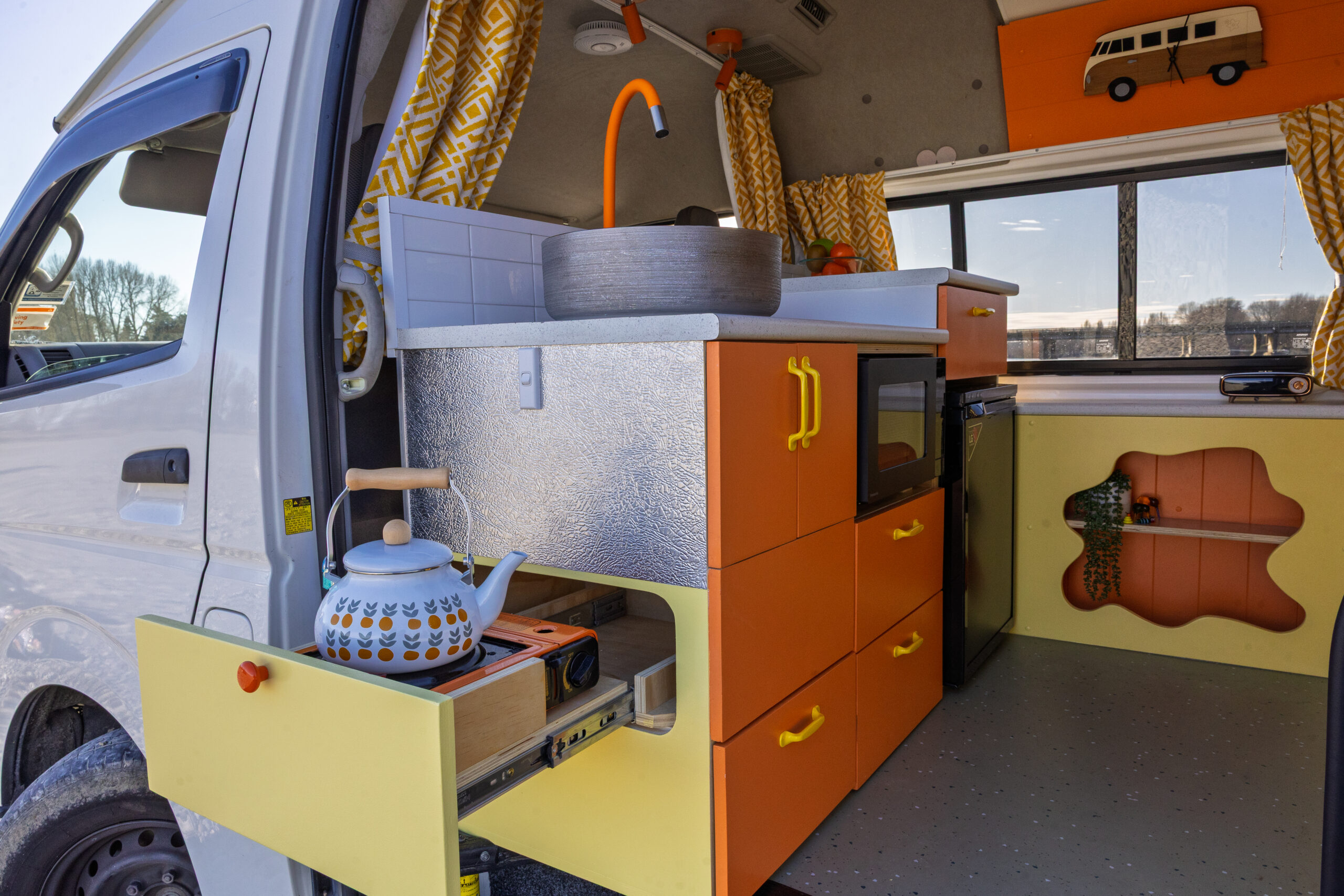 Inside Chester campervan with a kettle on the hob, view through the open door