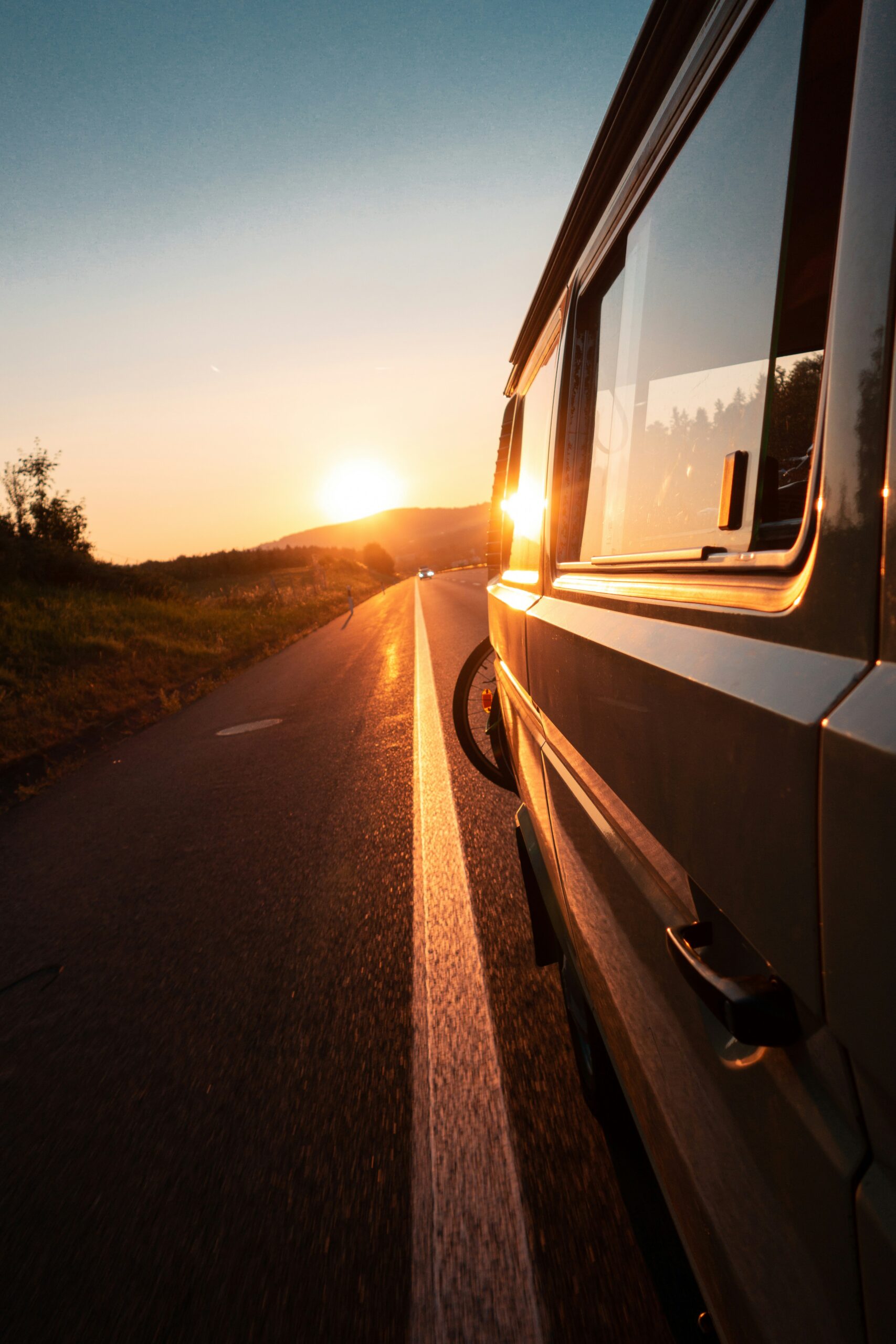 Campervan on a New Zealand road at sunset