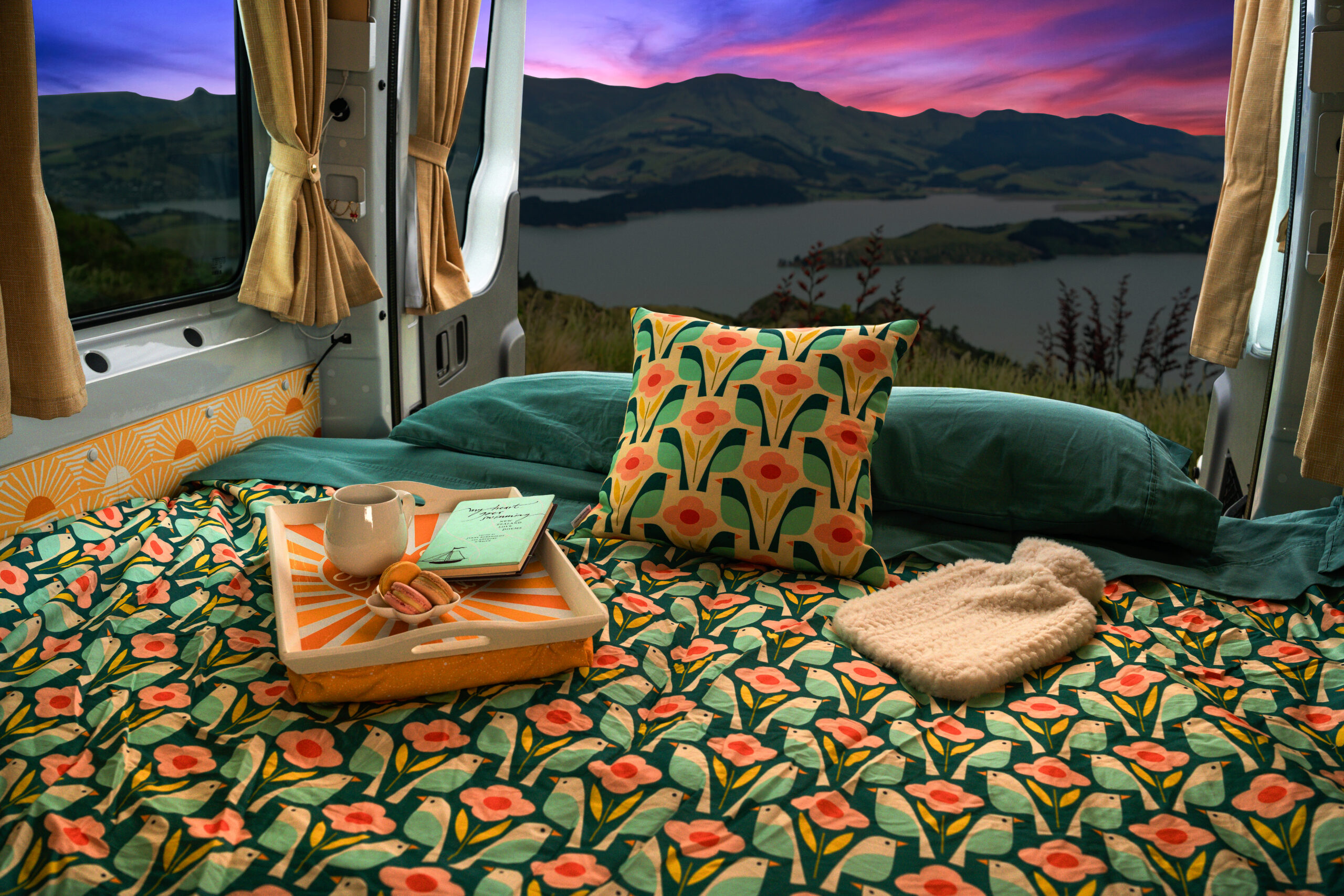 A handcrafted Quirky campervan interior looking out over the landscape at sunset