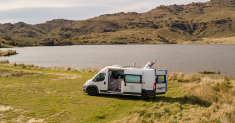 Campervan parked next to water