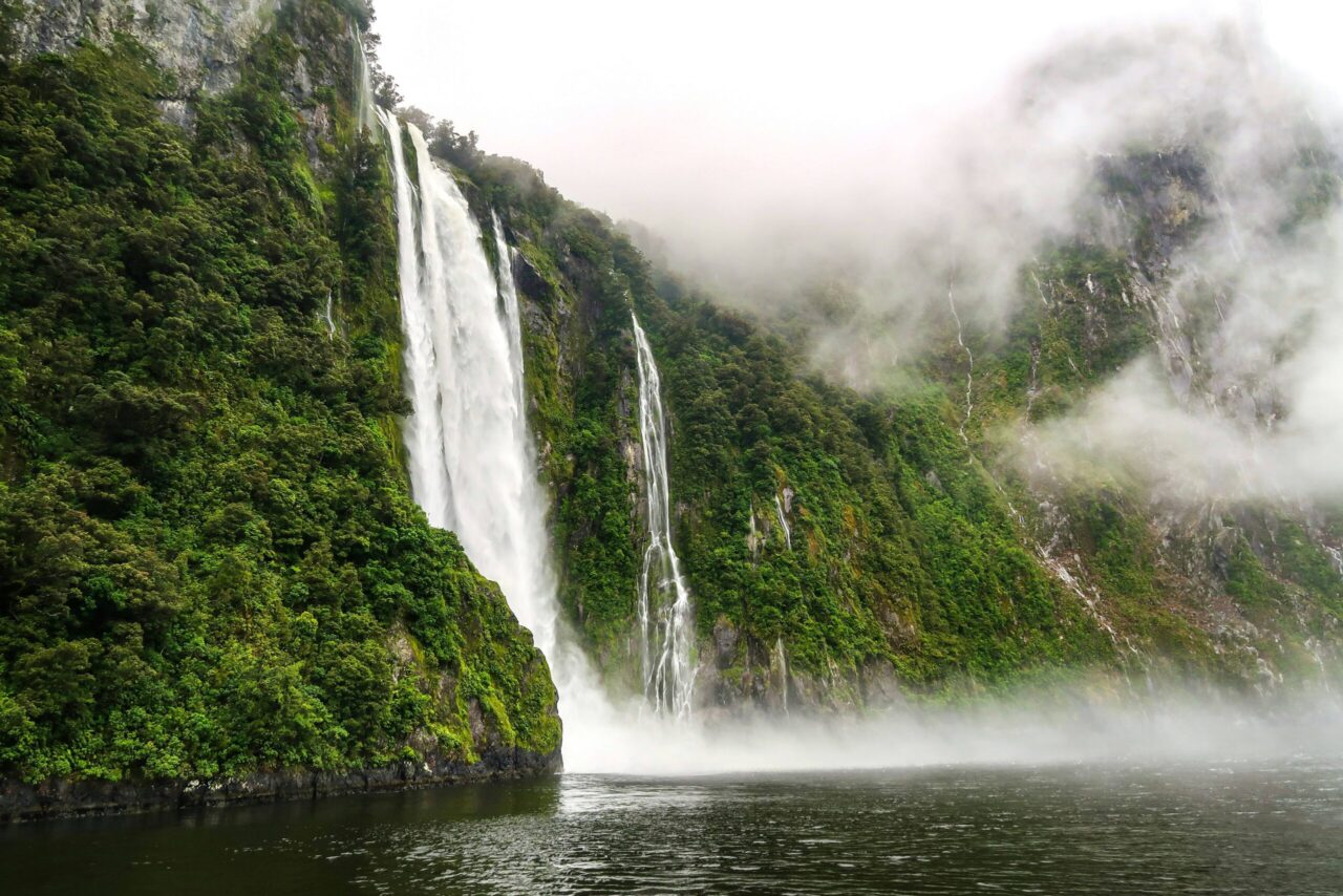 A waterfall tumbling down a sheer cliff face into Milford Sound