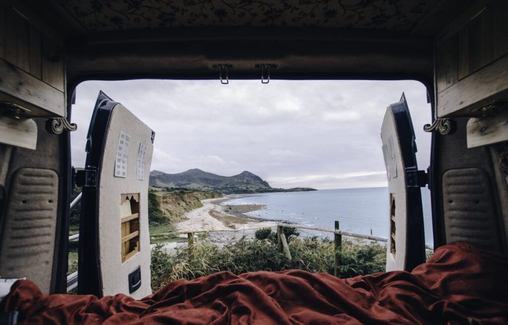 The view from an open campervan overlooking the coast of wales
