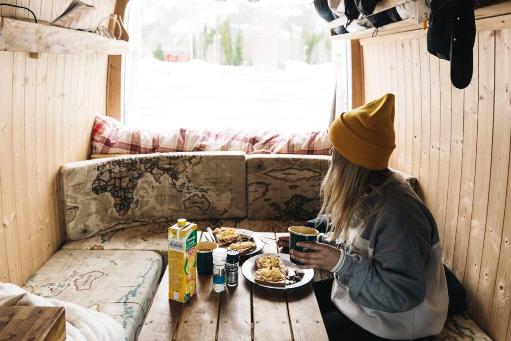 a woman having breakfast in a campervan