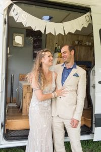 A bride and groom at their alternative wedding in a campervan