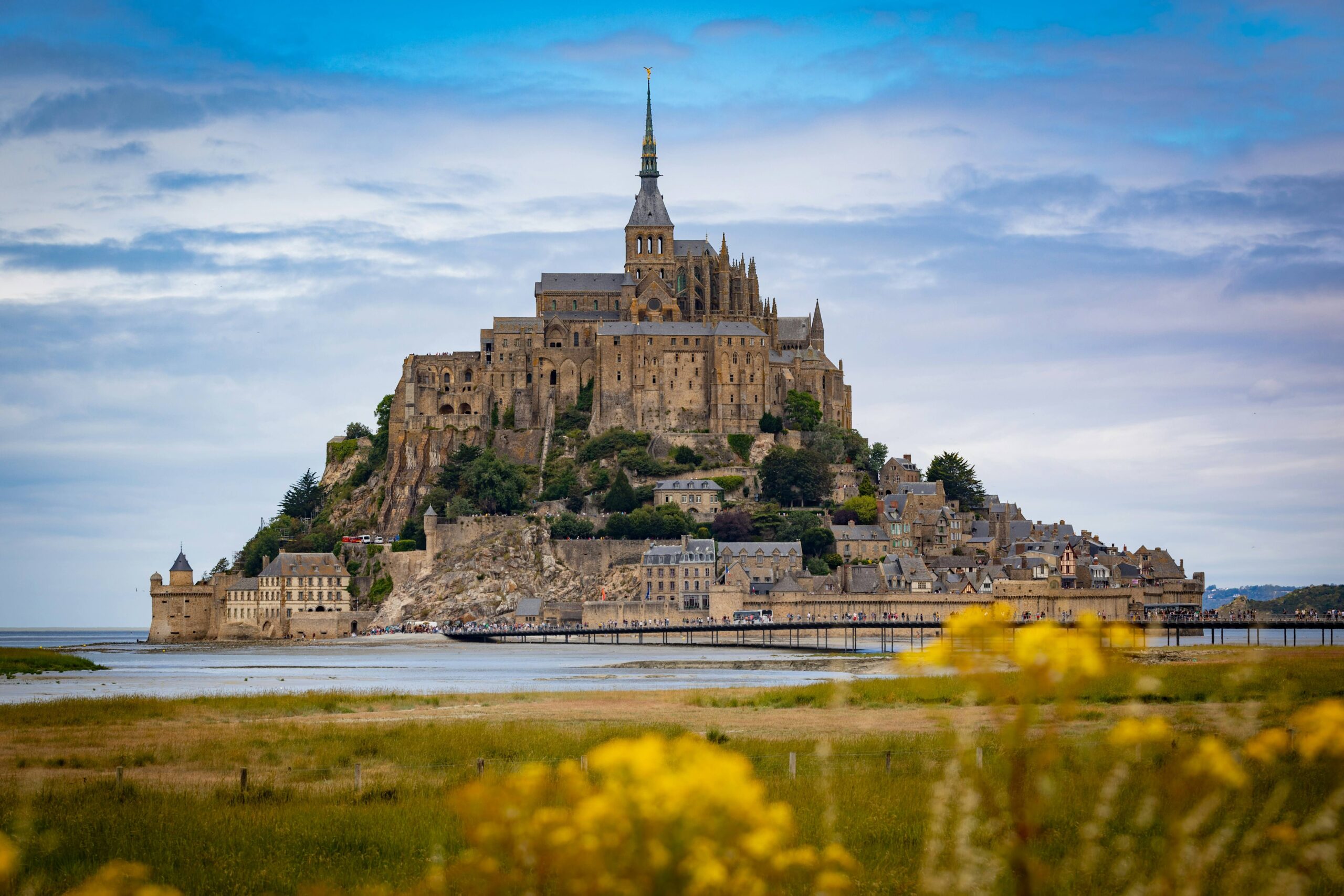 Mont Saint-Michel rises dramatically from the sea, showcasing its medieval architecture and surrounding tidal waters in Normandy, France.