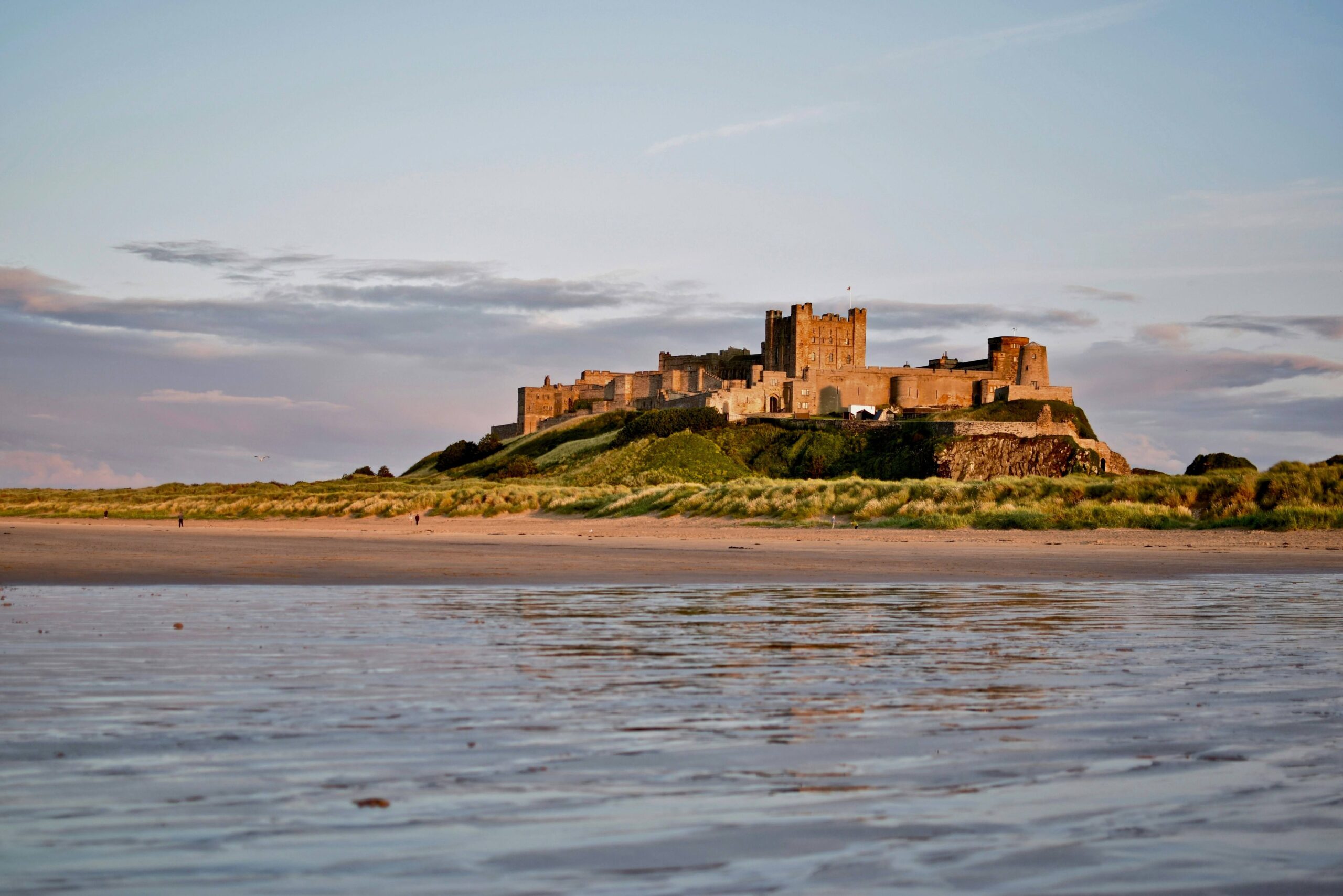Bamburgh castle and it's surrounding beach with ocean in the foreground