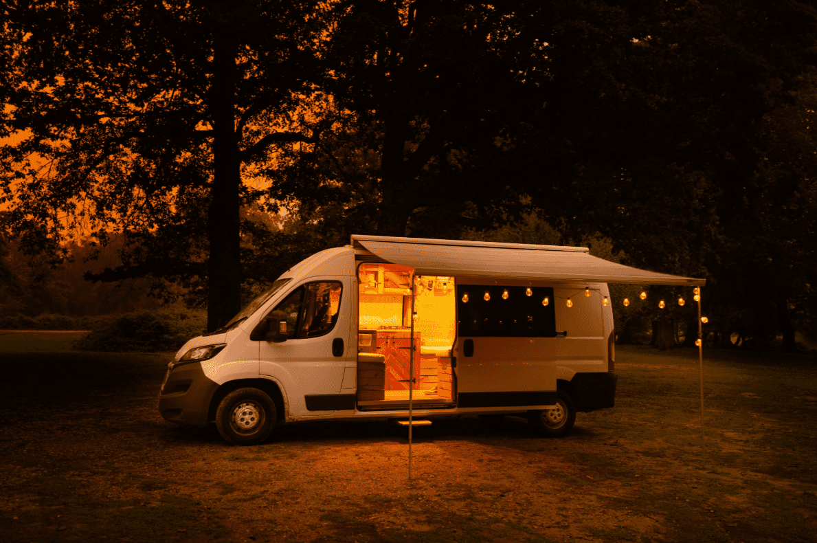 Festival campervan for hire lit up with fairy lights in the dark