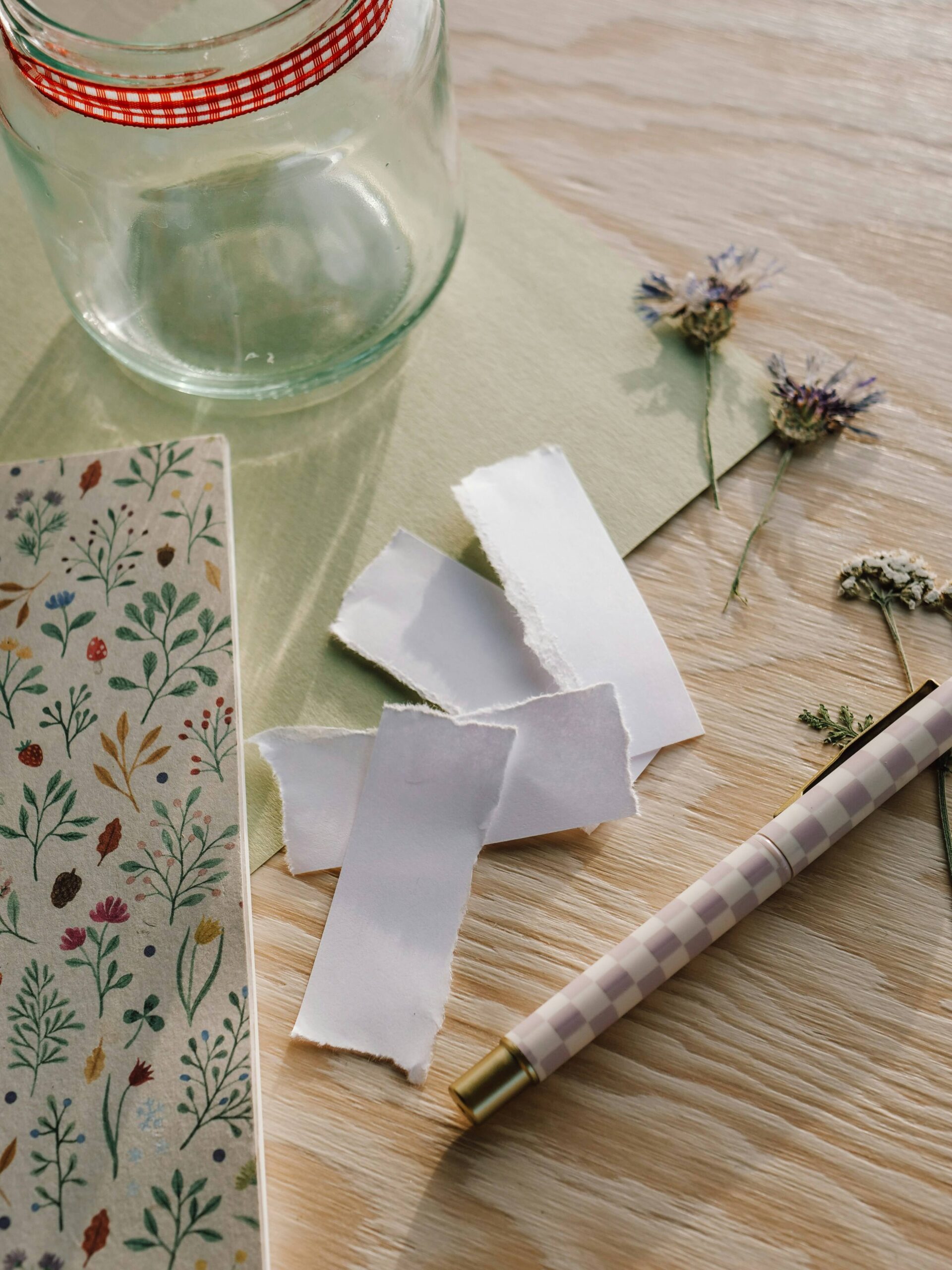 Slips of paper laid on a table accompanied by a pen and note book