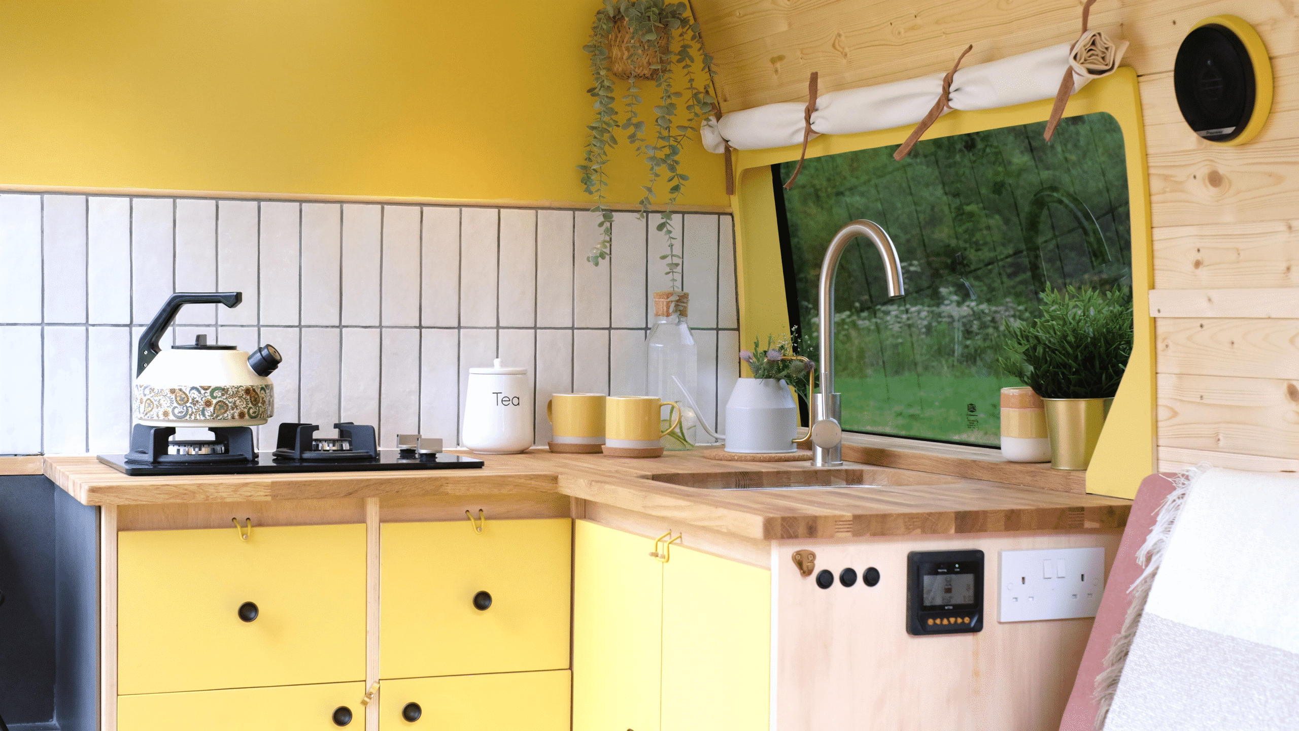 A butter yellow campervan kitchen